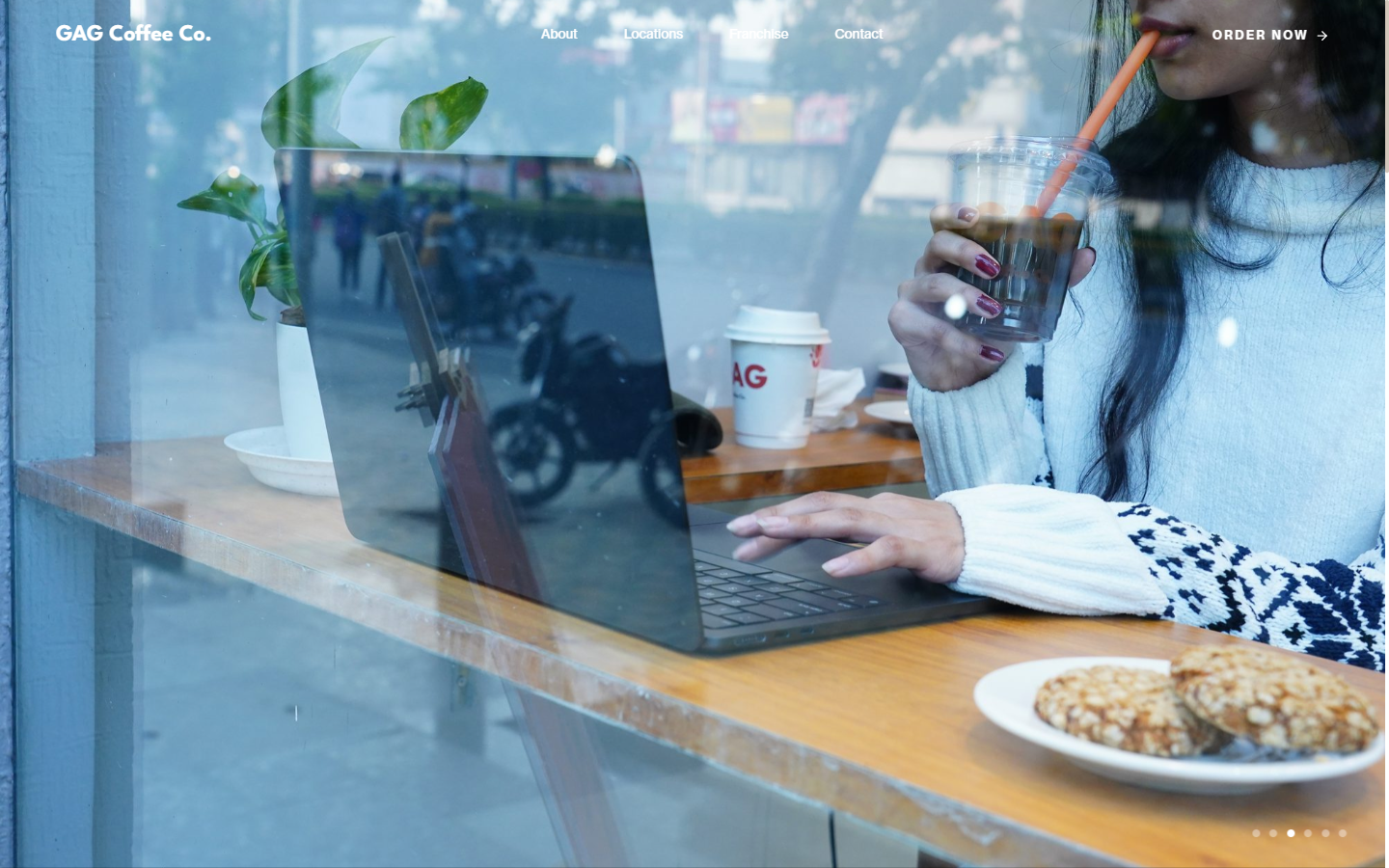 GAG Coffee Co. cinematic hero — laptop and iced coffee at a window-side cafe